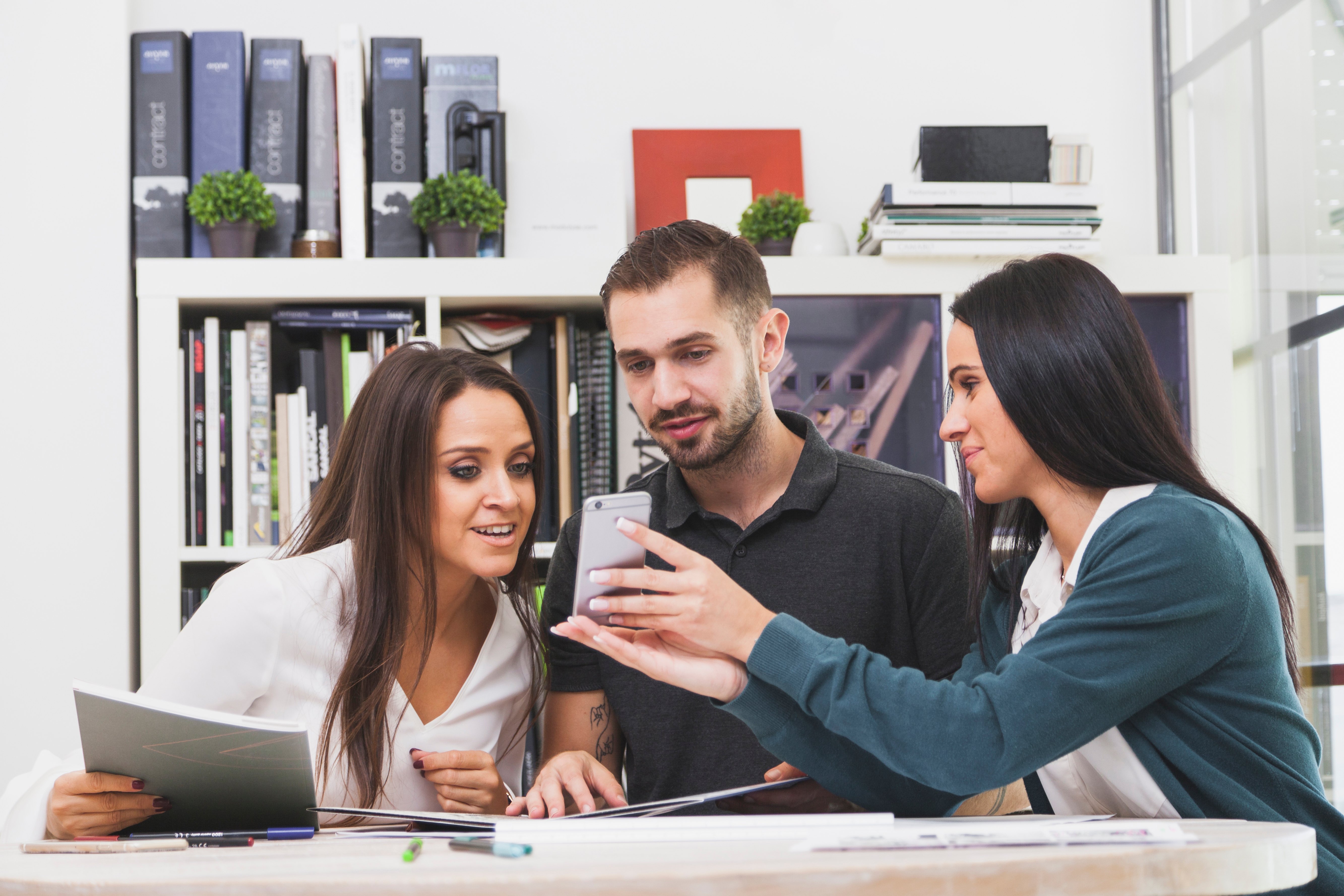 woman-showing-smartphone-colleagues